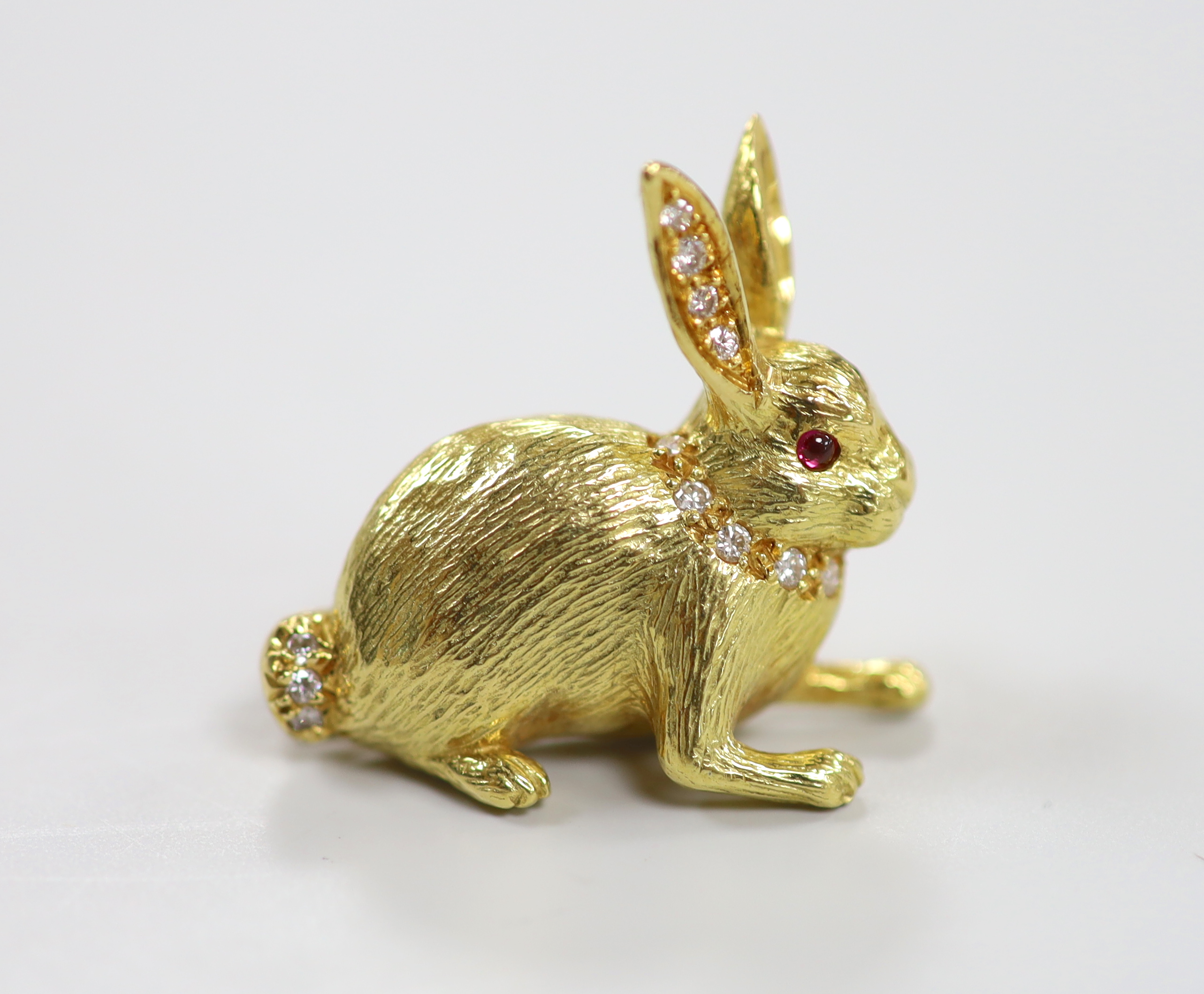 A modern 18ct yellow gold, diamond and ruby set novelty brooch, in the form of a seated hare, marked and initialled EW & Co, 27mm, gross weight 14.7 grams.